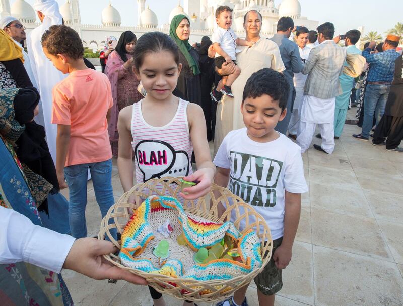Abu Dhabi, UNITED ARAB EMIRATES - Sweet treats for kids after performing morning prayers on the first day of Eid-Al Fitr at the Sheikh Zayed Grand Mosque.  Leslie Pableo for The National