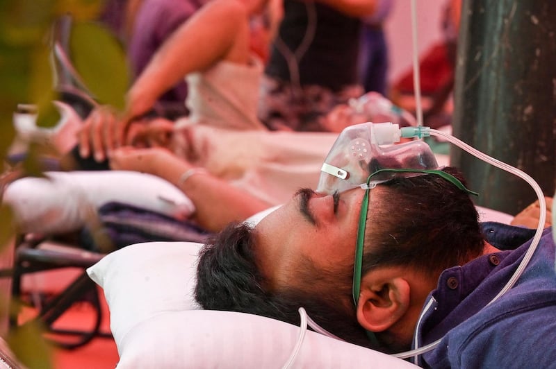 A Covid-19 patient breathes with the help of oxygen provided by a gurdwara, a place of worship for Sikhs. The tent along the roadside in Ghaziabad is helping people who need oxygen support. AFP