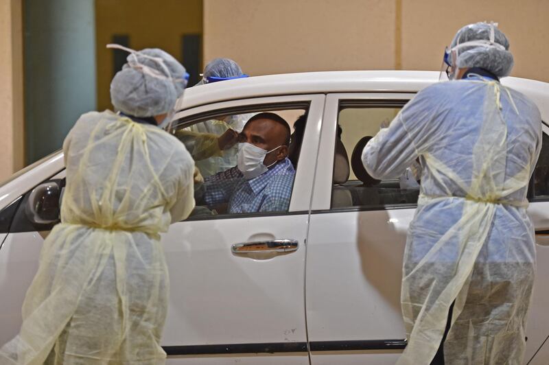Health workers perform a nose swab test during a drive through coronavirus test campaign held in Diriyah hospital in Riyadh. AFP