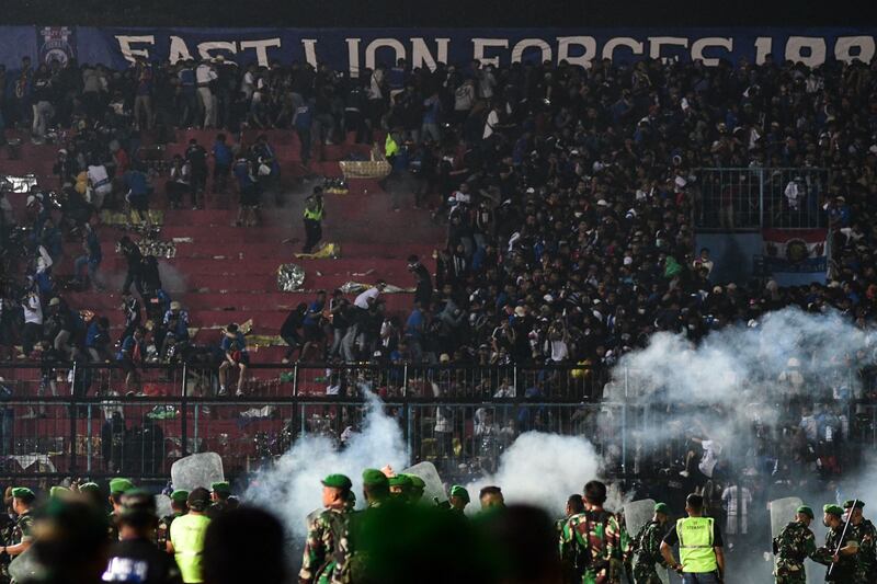 Security personnel on the pitch at Kanjuruhan Stadium as chaos ensues in the stands. AFP