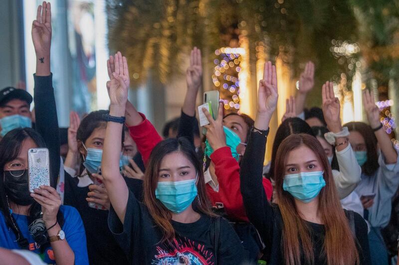 Pro-democracy activists flash three-fingered salutes while listening to the national anthem outside Siam Paragon, one of the largest shopping malls, in Bangkok, Thailand. Thailand's Cabinet on Tuesday approved a request to recall Parliament for a special session to deal with the political pressures from ongoing anti-government protests. The Cabinet at its weekly meeting approved the request, which calls for a non-voting session on Oct. 26-27. AP Photo