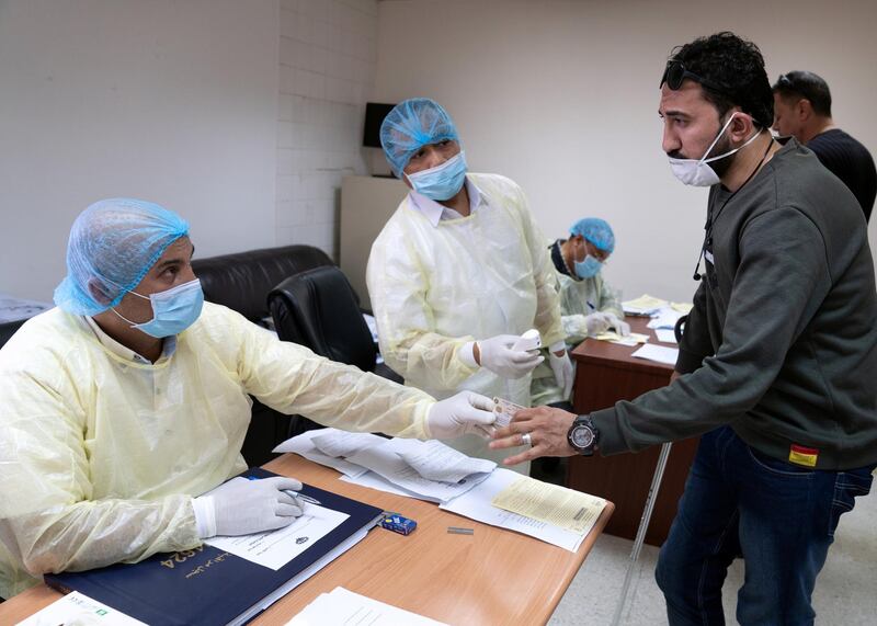 An expatriat, takes a coronavirus clearance certificate from a doctor at a health clinic in Subhan, Kuwait March 9, 2020. Reuters