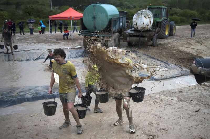 Runners take part in 'The Mud Day challenge', a 13-kilometre obstacles course, on in Beynes near Paris, on Saturday. Martin Bureau / AFP