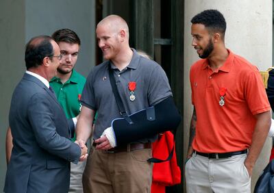 FILE - In this Aug. 24, 2015 file photo, French President Francois Hollande bids farewell to U.S. Airman Spencer Stone as U.S. National Guardsman Alek Skarlatos of Roseburg, Ore., second from left, and Anthony Sadler, a senior at Sacramento State University in California, right, after Hollande awarded them the French Legion of Honor at the Elysee Palace in Paris. The three Sacramento-area men are lorded for their bravery in thwarting a terror attack on a French train in 2015. Islamic State operative Ayoub El Khazzani goes on trial in France Monday Nov. 16, 2020, on terror charges for appearing on a train with an arsenal of weapons and shooting one passenger in 2015. (AP Photo/Michel Euler, File)