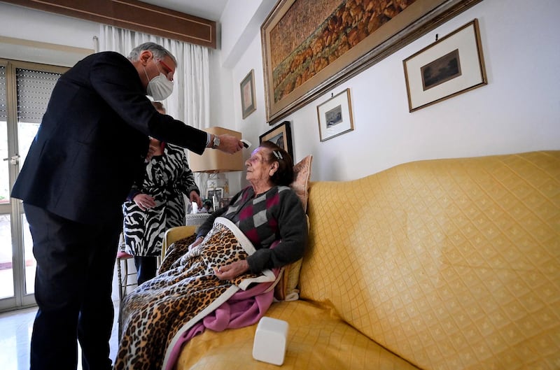 A family doctor administers a vaccine to his 100 year old patient named Amelia in Rome, Italy. EPA