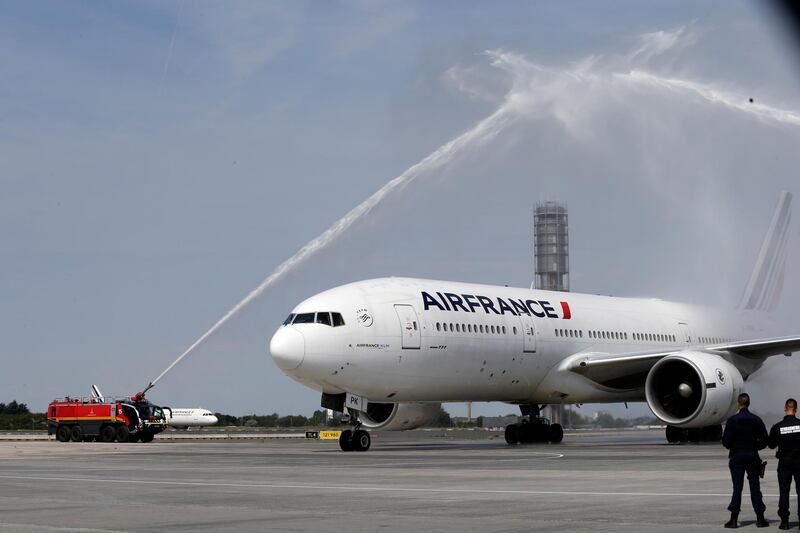 The plane carrying the French football team is met with a water cannon salute at Charles de Gaulle airport. Bob Edme / AP Photo