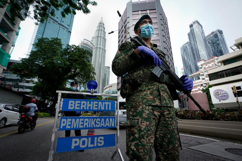 An armed soldier stands guard at a roadblock on the first day of a movement control order in downtown Kuala Lumpur, Malaysia. AP Photo