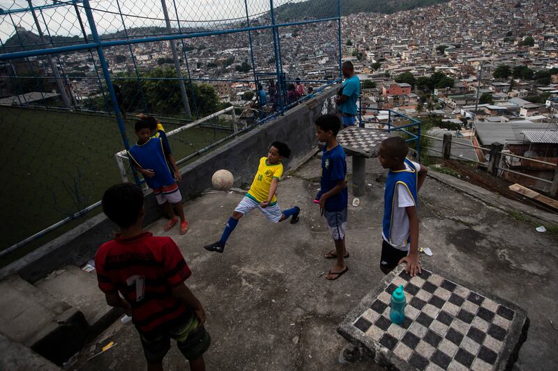 Boys play football in the Complexo da Penha favela, in Rio de Janeiro. AP