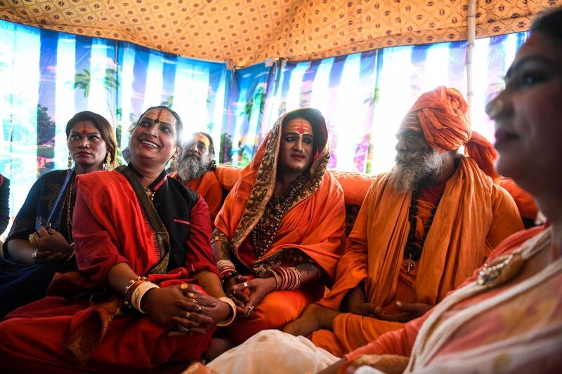 In this photograph taken on January 14, 2019, Laxmi Narayan Tripathi (C), a transgender rights activist and chief of the Kinnar Akhara monastic Hindu order made up of transgender members, meets with Hari Gigi (centre R), head of the Hindu sadhu community Juna Akhara at the Kumbh Mela festival in Allahabad.  For decades Laxmi Narayan Tripathi has fought untiringly India's conservative laws and beliefs to put her transgender community on a par with the rest of society, and now she has notched up a new milestone. On January 15 she and dozens of other resplendent "Kinnars" splashed in the sacred waters of the Ganga and Yamuna rivers alongside top Hindu ascetics at the immense Kumbh Mela festival in northern India.
 - 
 / AFP / CHANDAN KHANNA
