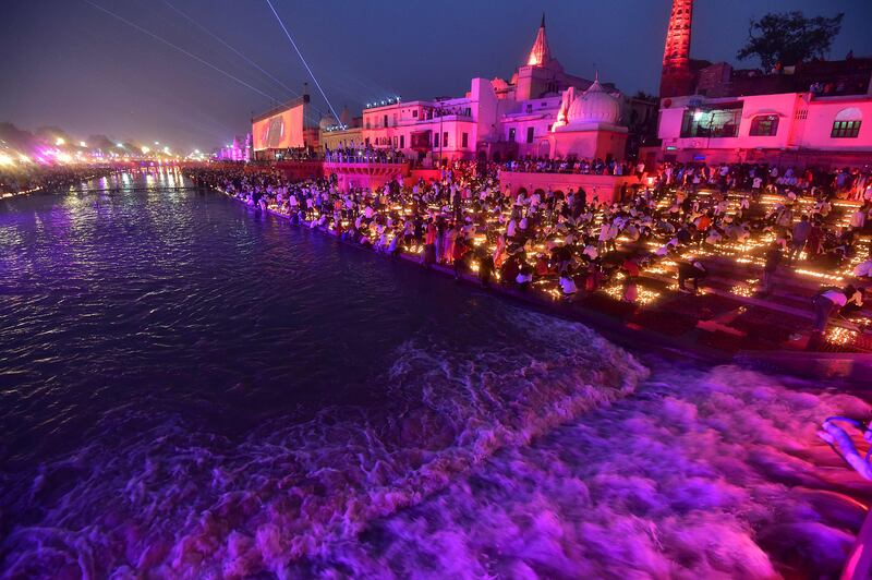 Devotees light earthen lamps on the banks of the Saryu river in Ayodhya on Saturday. AFP