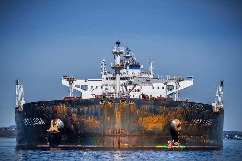 Greenpeace activists in a rubber dinghy sail close to a  Russian oil tanker during a protest in Norway on April 25. EPA