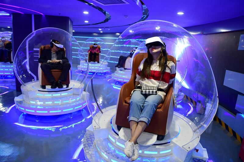 People wearing virtual reality headsets watch films at a newly opened VR cinema in Beijing, China. Reuters
