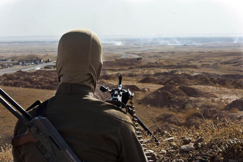 A member of Kurdish Peshmerga forces takes position overlooking militants of the Islamic State of Iraq and the Levant (ISIL) positions in Jalawla in the Diyala province, on June 14, 2014. AFP Photo / Rick Findler