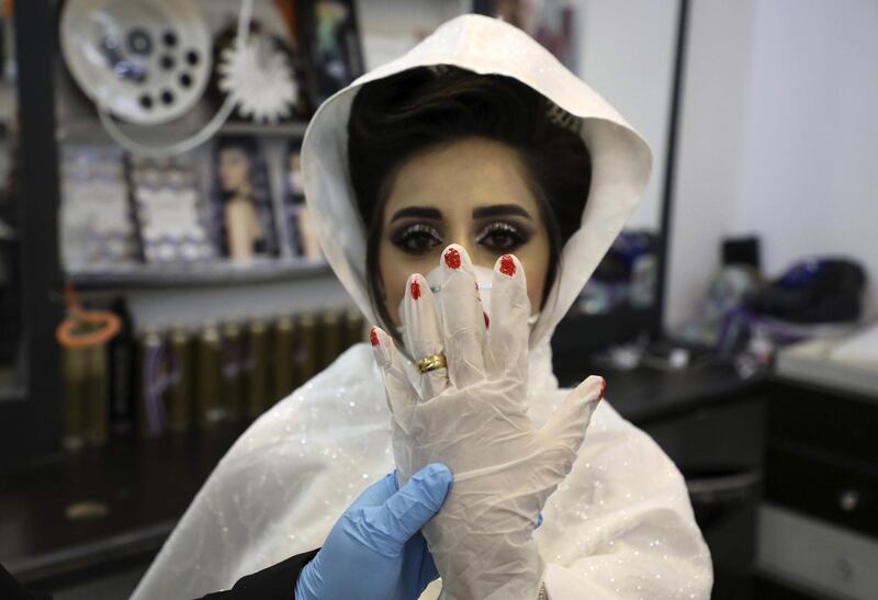 Palestinian bride Baraa shows off her ring over a glove at a salon in the West Bank village of Dora near Hebron. AFP
