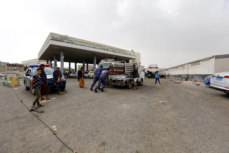 Yemeni soldiers help push a mini-truck at a petrol station in Sanaa.  EPA