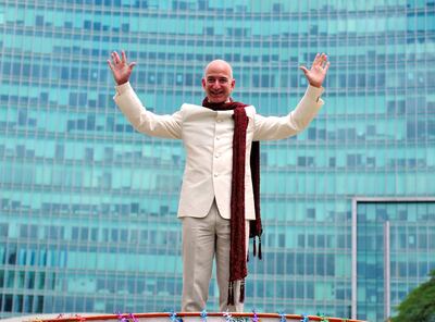 FILE PHOTO: Jeff Bezos, founder and chief executive officer of Amazon, poses as he stands atop a supply truck during a photo opportunity at the premises of a shopping mall in Bangalore, India, September 28, 2014. REUTERS/Abhishek N. Chinnappa/File photo