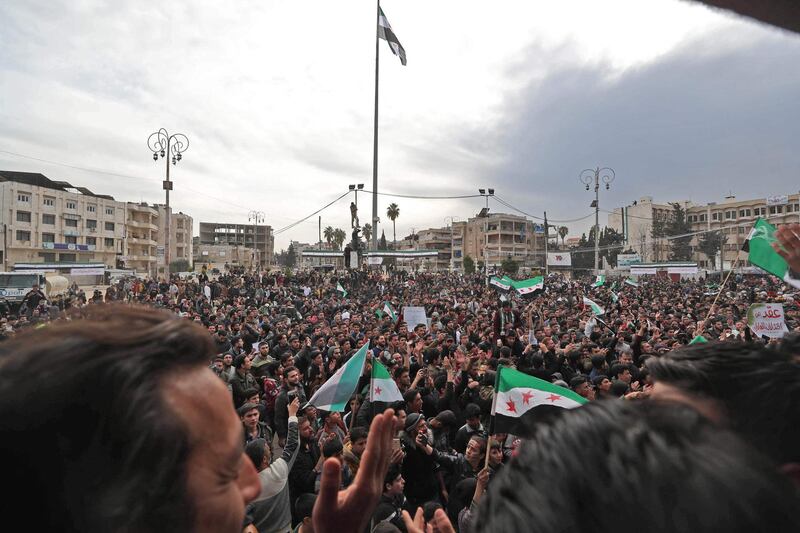 Protesters wave flags of the Syrian opposition during a demonstration in Syria's rebel-held city of Idlib. AFP
