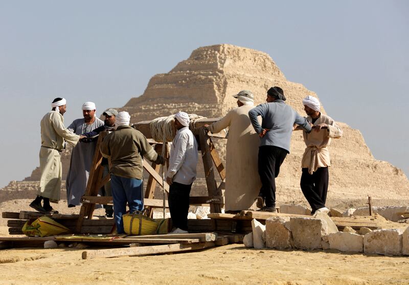 Workers at the  Saqqara site, against a backdrop of the Step Pyramid of Djoser. Reuters