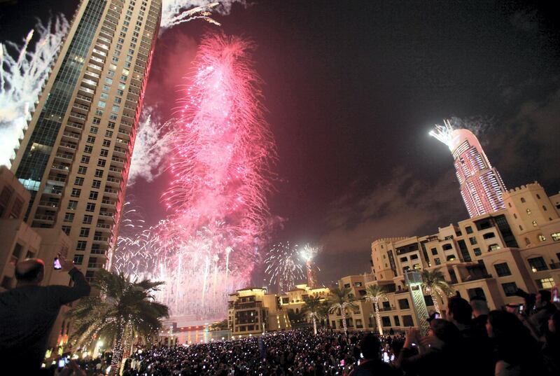 Fireworks illuminate Burj Khalifa while thousands of people gather to celebrate the New Year at midnight in Dubai on January 1, 2013.  AFP PHOTO/STR (Photo by STR / AFP)