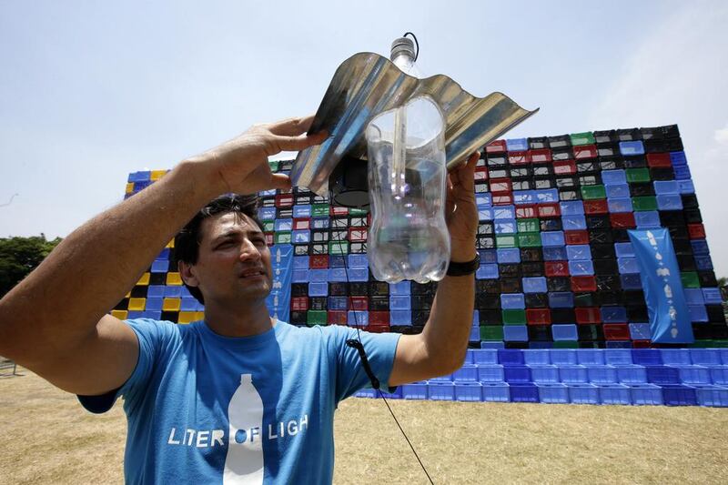 Filipino entrepreneur and environment activist Illac Diaz demonstrates his solar-powered bottle bulb. Mr Diaz’s sustainable energy project has provided light to thousands of homes in the Philippines and elsewhere around the world since 2010. Dennis M Sabangan / EPA