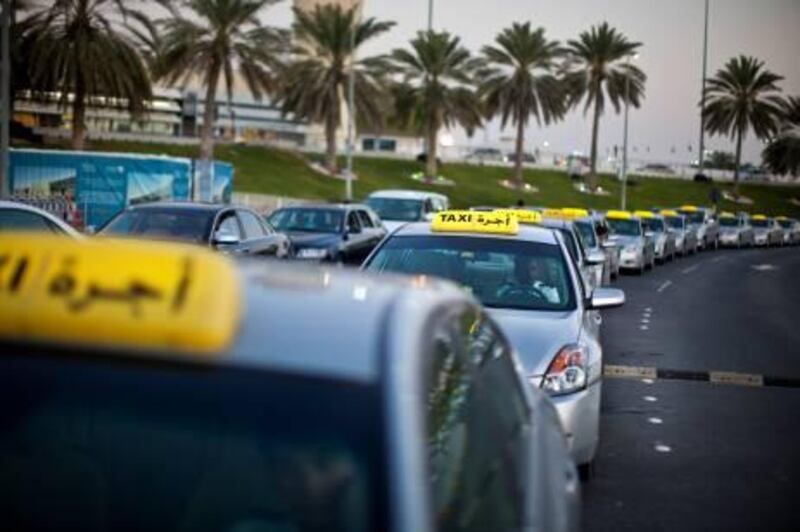 Metered silver taxis and set-fee luxury cars wait in a queue in front of the Terminal 1 at the Abu Dhabi International Airport on Wednesday, Feb. 23, 2011, in Abu Dhabi. 
(Silvia Rázgová / The National)