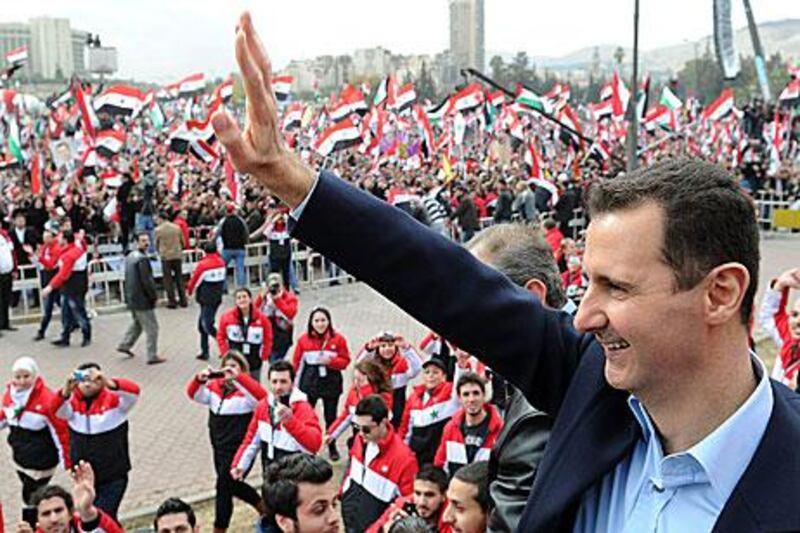 Bashar Al Assad, the Syrian president, waves to supporters during a rare public appearance in Damascus yesterday.