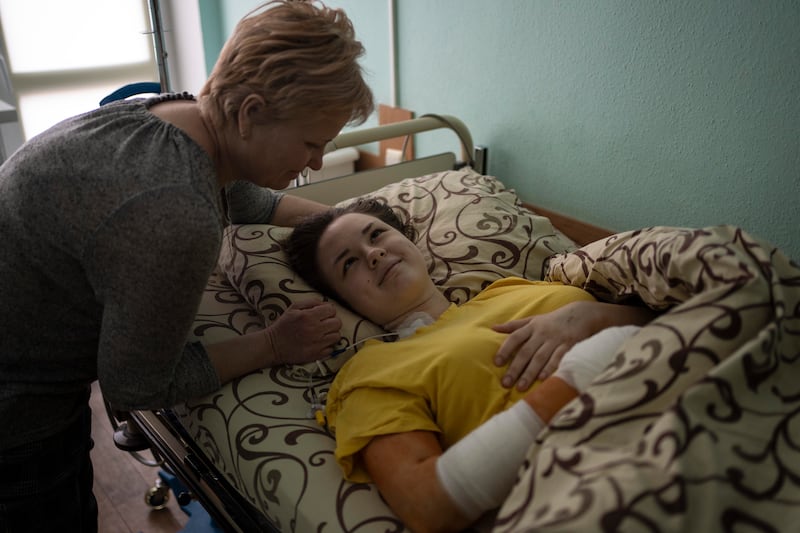 Nastya Kuzyk, 20, who was injured in an attack on Chernihiv, is comforted by her mother Svitlana, 50, as she recovers in a Kyiv hospital. AP
