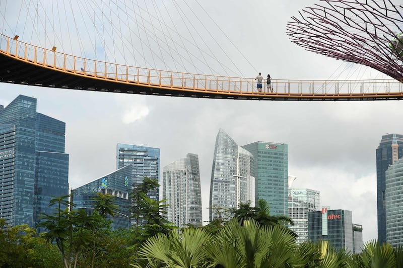 TOPSHOT - A couple enjoys the view of the skyline from the aerial walkway of the Garden by the Bay's Supertree Grove in Singapore on August 30, 2017. / AFP PHOTO / Roslan RAHMAN