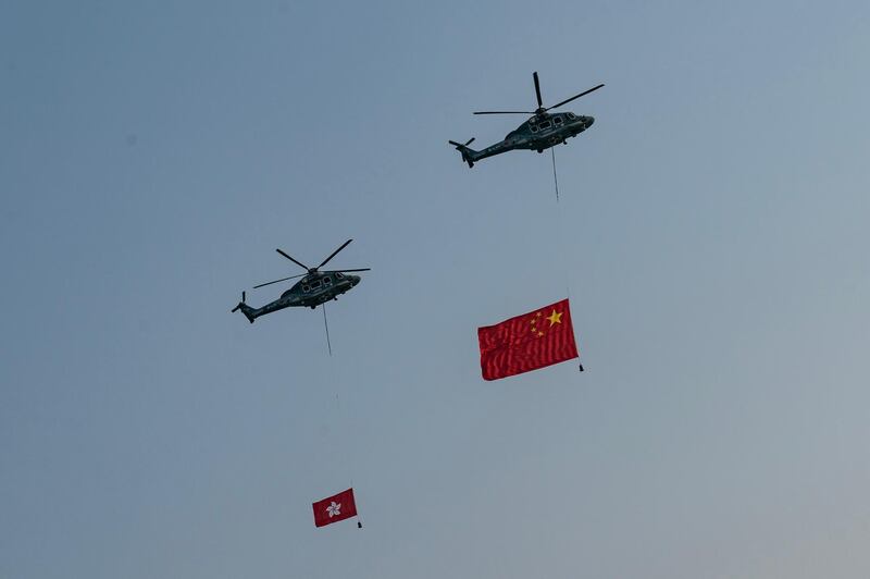 Helicopters fly the flags of China and Hong Kong over Victoria Harbor in Hong Kong. Getty