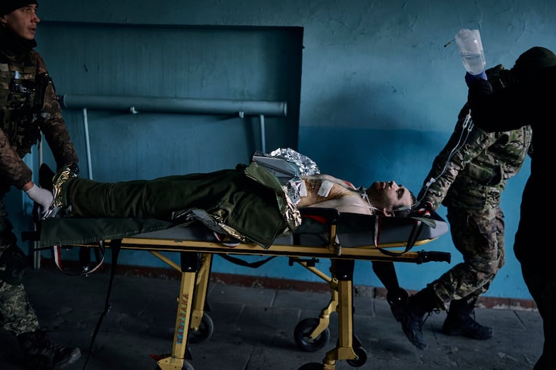 A Ukrainian soldier is wheeled on a stretcher at a hospital in the Donetsk enclave. AP