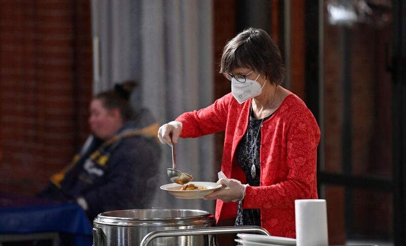 A volunteer dishes out food at a soup kitchen for the needy and homeless in the Holy Cross church in Berlin's Kreuzberg district. AFP
