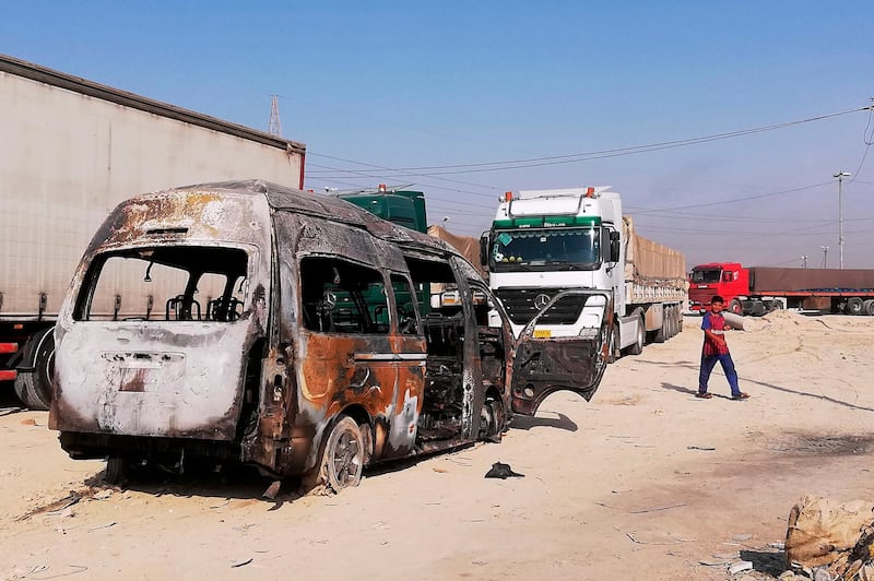 A destroyed minibus sits near an Iraqi army checkpoint about 10 kms. (6 miles) south of Karbala, Iraq, Saturday, Sept. 21, 2019. A bomb exploded on a minibus packed with passengers outside the Shiite holy city of Karbala Friday night, killing and wounding civilians, Iraqi security officials said. (AP Photo/Hadi Mizban)