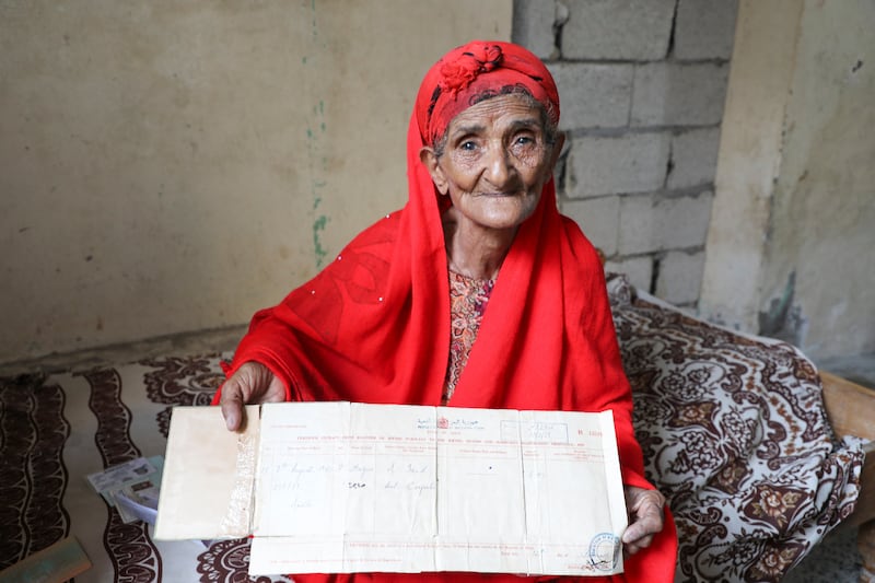Kulthoom Muhammad Saeed, 80, shows her birth certificate as she talks to Reuters at her home about memories of the Queen Elizabeth's visit to Aden in 1954 during the period that Aden was a colony within the British Empire, in Aden,Yemen September 11, 2022.  REUTERS / Fawaz Salman