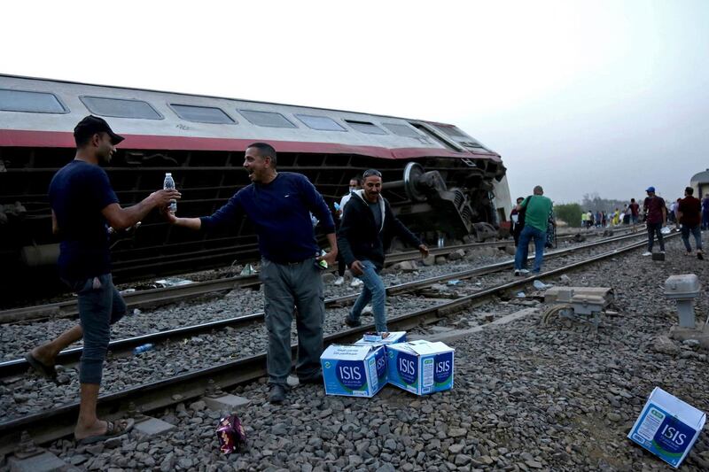 People break their fast at the scene of a passenger train derailment near Banha, the capital of Qalyubia province, Egypt. AP Photo