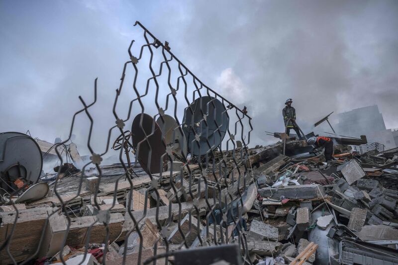 Palestinian firemen check the remains of a residential building destroyed by Israeli airstrikes in Gaza City. AFP