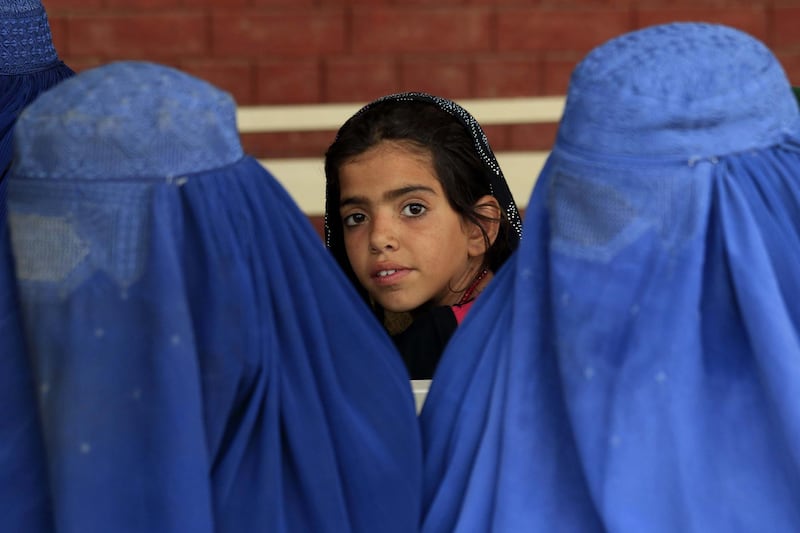 An Afghan refugee poses for a photograph as she waits to leave with her family at a UN registration centre in Azakhel area of Nowshera, Khyber Pakhtunkhwa province, Pakistan. EPA