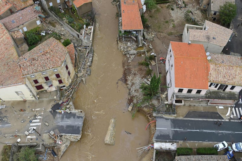 An aerial view shows a collapsed bridge in the city of Villegailhenc, near Carcassonne, southern France, on October 15, 2018, following heavy rains that saw rivers bursting banks. At least 13 people died as violent rainstorms turned rivers into raging torrents in southwestern France on October 15 in the latest episode of wild weather in Europe, officials said. Flash floods swamped a number of towns and villages around the fortress city of Carcassonne, leaving a trail of overturned cars, damaged roads and collapsed homes / AFP / SYLVAIN THOMAS
