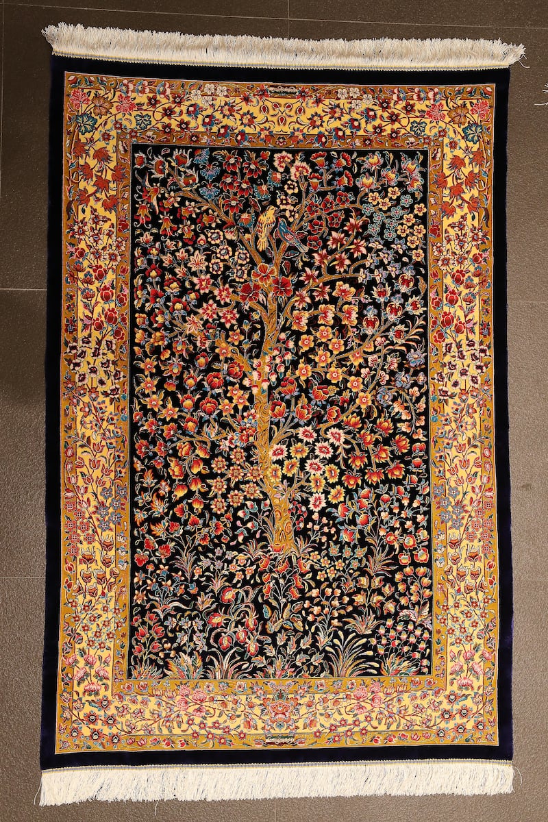 An Iranian machine-made silk Tree of Life design carpet priced at Dh4,980.