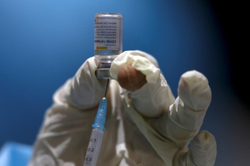 A nurse prepares a dose of vaccine against Covid-19 during a vaccination session for people with disabilities and the elderly, at the Exhibition Center in Quito, Ecuador. EPA