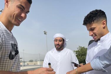 Cristiano Ronaldo, left, signs an Al Wasl shirt with Wasl midfielder Ali Saleh, right. Courtesy Twitter