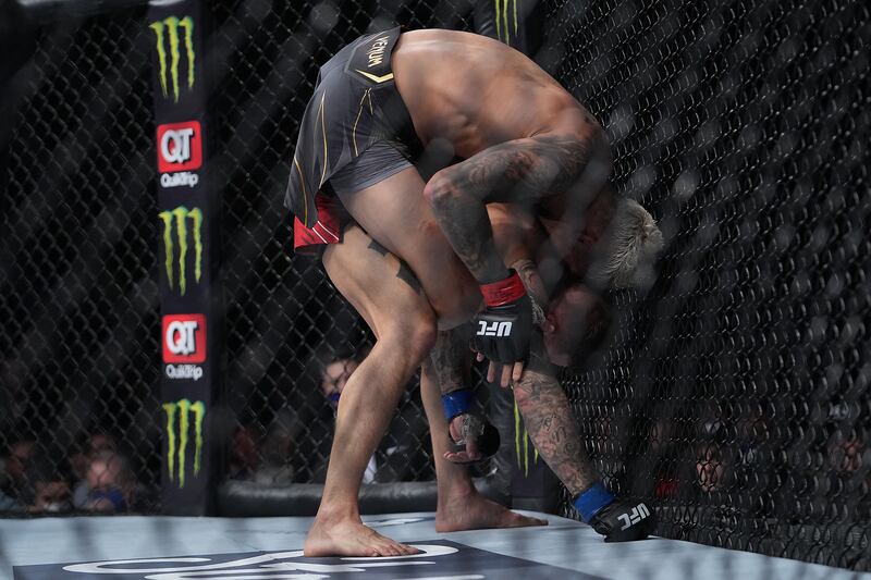 Charles Oliveira applies a hold against Dustin Poirier. Reuters