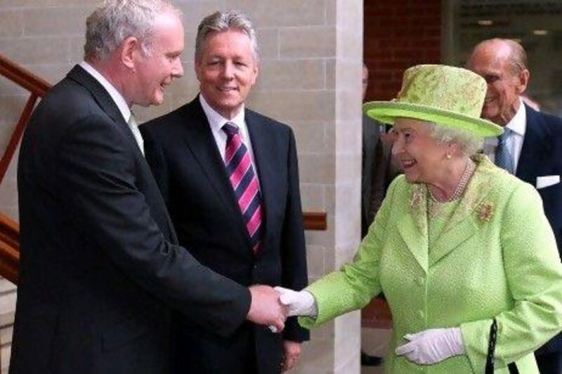 Britain's Queen Elizabeth II shakes hands with Northern Ireland deputy first minister Martin McGuinness (left), watched by first minister Peter Robinson and Prince Philip at the Lyric Theatre in Belfast, Northern Ireland.