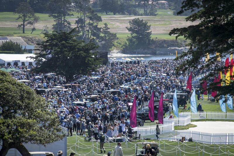 Attendees view cars along the 18th fairway. Bloomberg