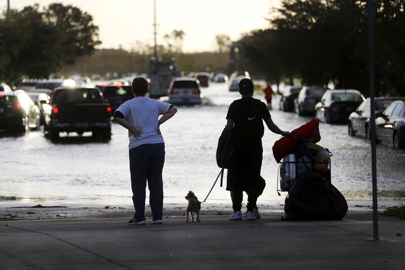 Evacuees leave the Germain Arena, which was used as an evacuation shelter for Hurricane Irma, which passed through yesterday, in Estero, Fla., Monday, Sept. 11, 2017. (AP Photo/Gerald Herbert)