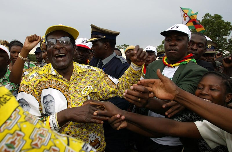 Zimbabwe president Robert Mugabe and leader of the ruling party ZANU PF greets a crowd of about 15,000 people at a golf course in Chinhoyi town some 120Km northwest of Harare during a pre-election rally.
AFP PHOTO Alexander JOE / AFP PHOTO / ALEXANDER JOE
