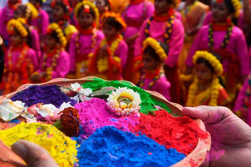 A participant holds a tray of coloured powder as students take part in a cultural procession to celebrate Holi, the spring festival of colours, in Kolkata on March 9, 2020. AFP