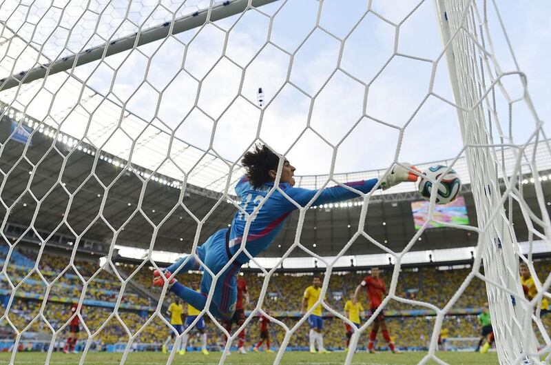 Mexico goalkeeper Guillermo Ochoa dives for the ball to make a save against Brazil during their match on Tuesday at the 2014 World Cup. Yuri Cortez / AFP