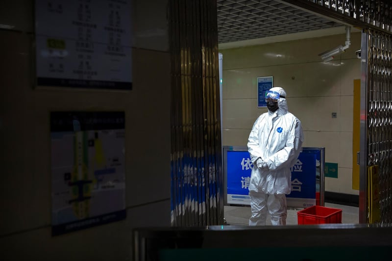 A worker wearing a hazardous materials suit stands at a security checkpoint at a subway station in Beijing. AP Photo