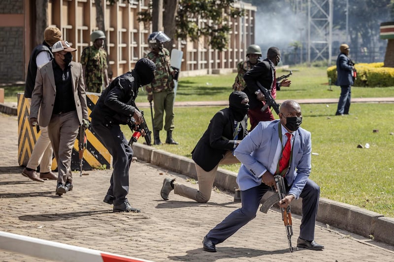 Police officers and security personnel protect the Kenyan Parliament as protesters try to storm the building during a nationwide strike to protest against tax hikes. AFP