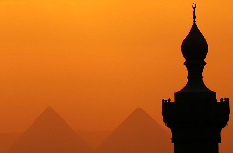 The sun sets on the minarets and the Great Pyramids of Giza in Old Cairo, Egypt. Reuters